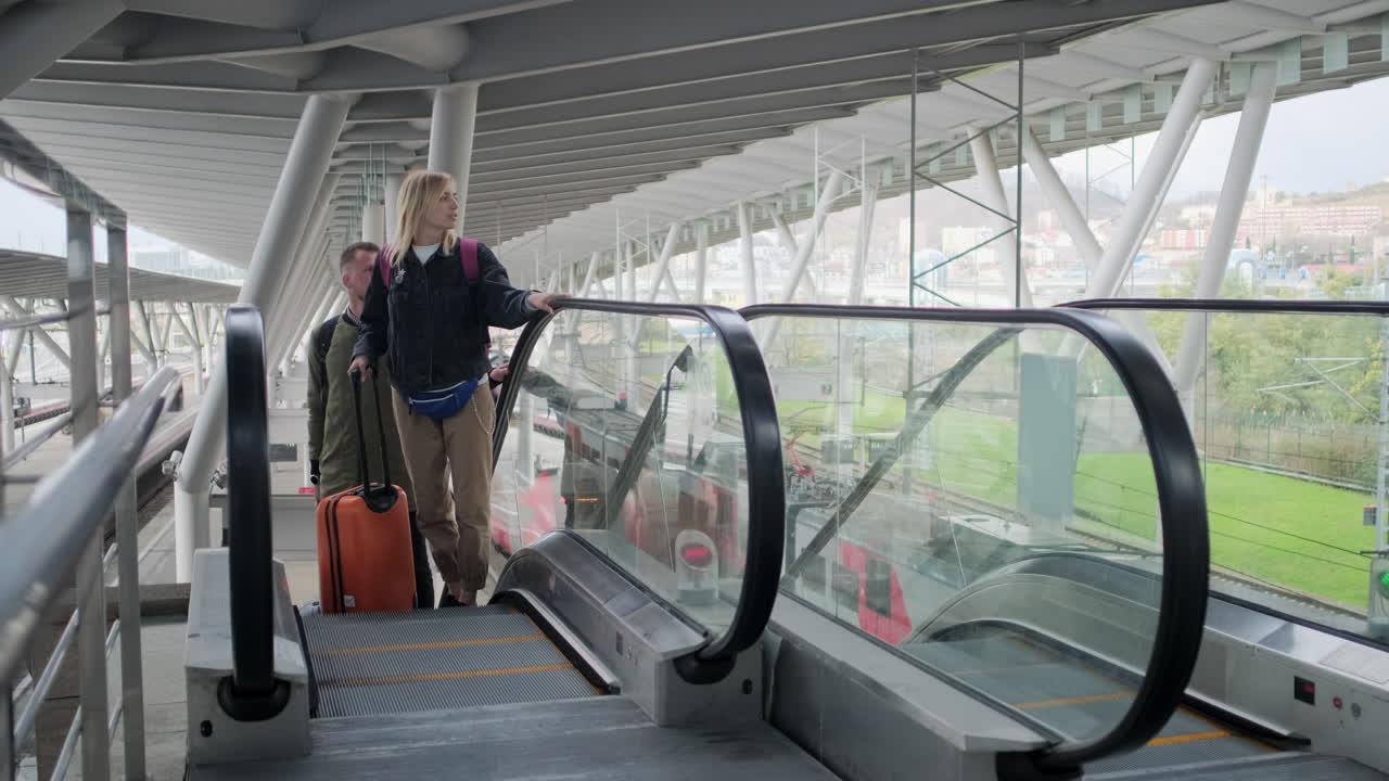 pasajeros que utilizan escaleras mecánicas en una estación de tren