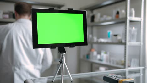 digital pad indoor of drugstore with pharmacist employee at background