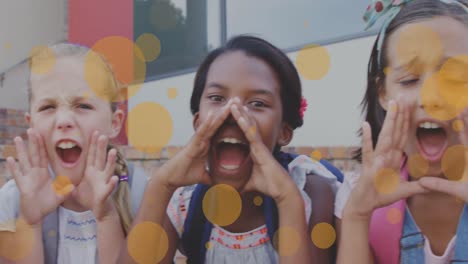 Animation-of-orange-circles-over-happy-diverse-schoolchildren-having-fun-shouting