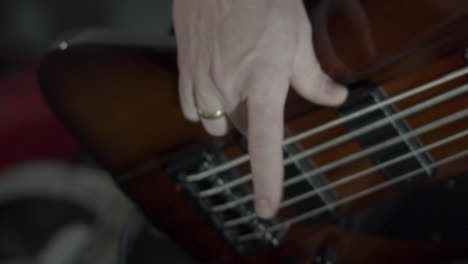 hand playing bass guitar intensely