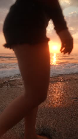 woman walking on the beach at sunrise