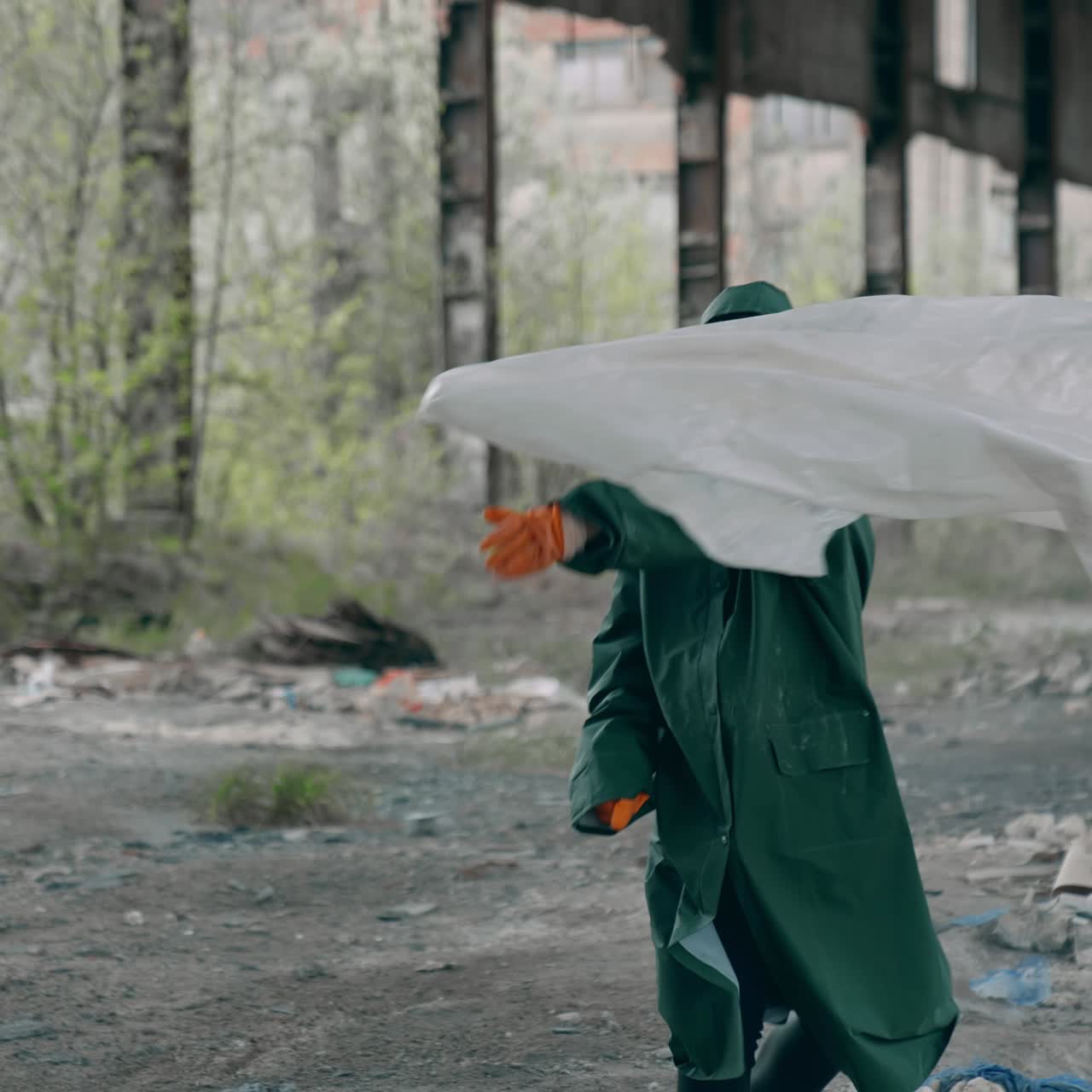 Survivor running in abandoned place. Human in protective suit and gas mask with cloth runs madly in ruined building on garbage background
