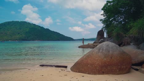 Un-Hermoso-Cinemagraph-4k-Uhd-De-Una-Playa-Tropical-Junto-Al-Mar-En-La-Isla-Perhentian,-Malasia-Y-Una-Modelo-Morena-En-Una-Roca