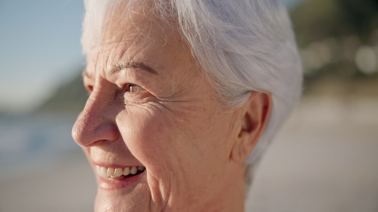 Senior woman, smile and sunset at a beach