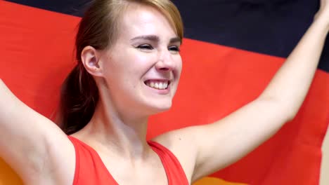 german young woman celebrates holding the flag of germany in slow motion