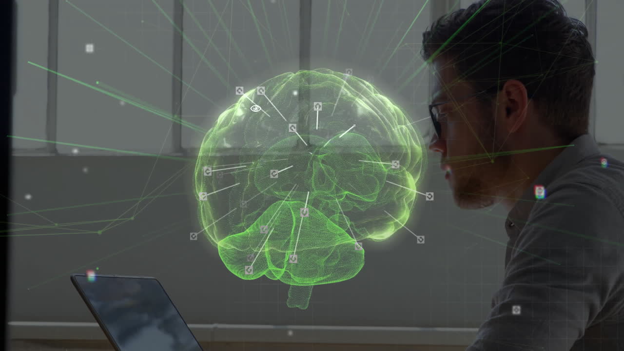 Male researcher leaning toward laptop in tech lab, interacting with glowing green holographic brain