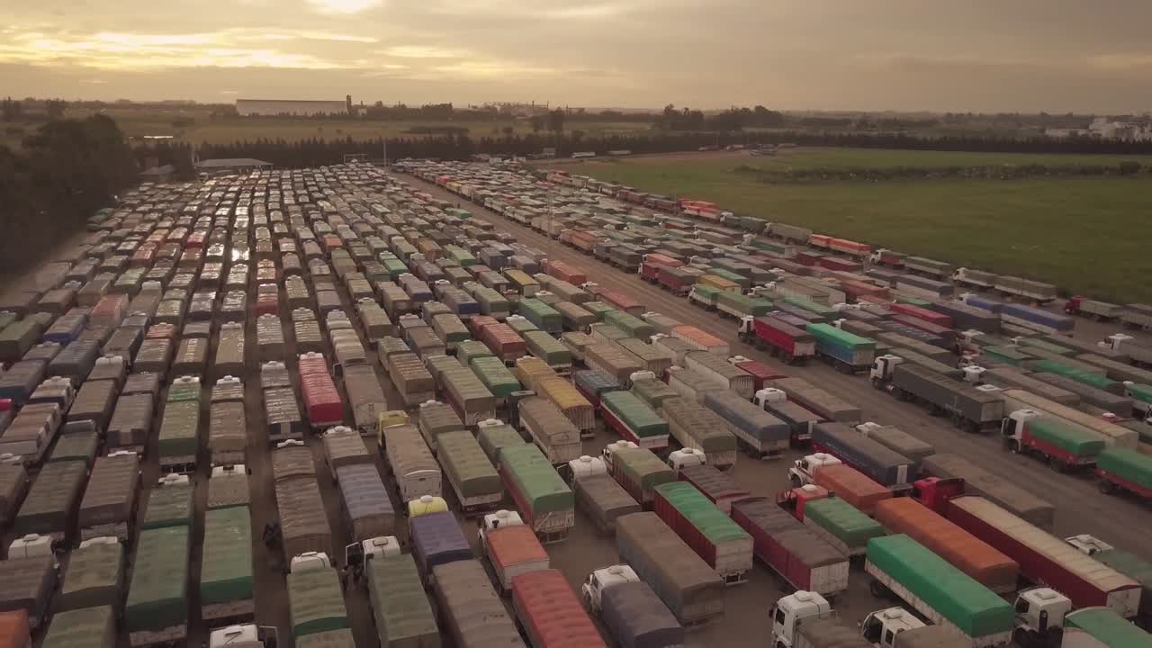 Aerial view of a bunch of cargo trucks with the sun behind