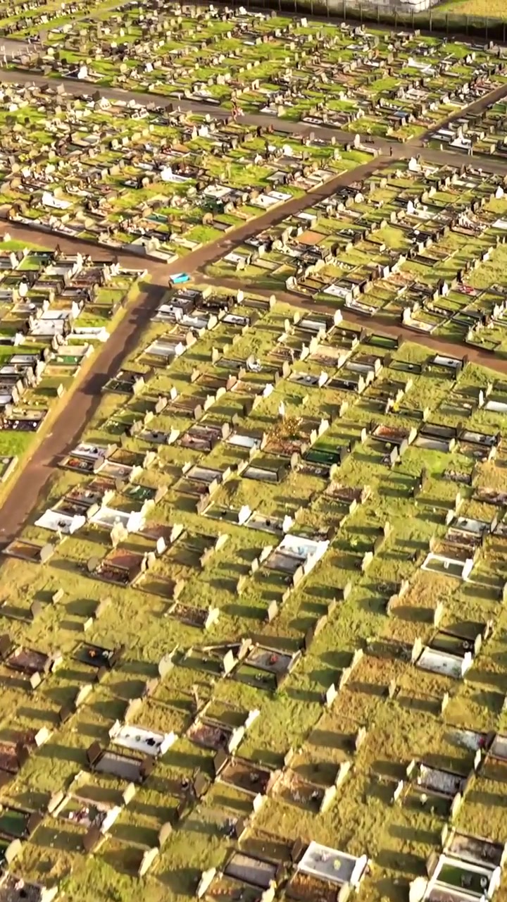 Ascending aerial video of Milltown Cemetary in West Belfast, Northern Ireland on a bright summer evening. Produced in 60FPS, 1080x1920 social ratio and with Rec709 colour.