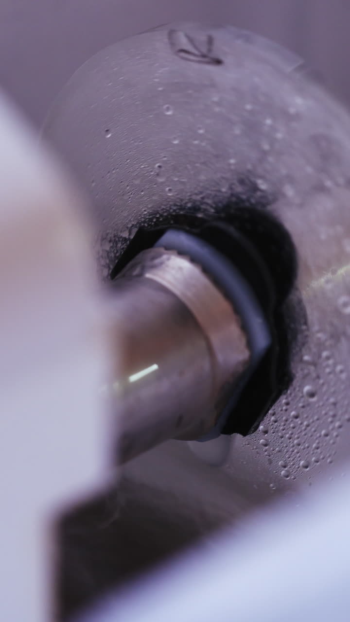 Cutting glasses lens. Man polishing glasses in optical shop. Vertical video