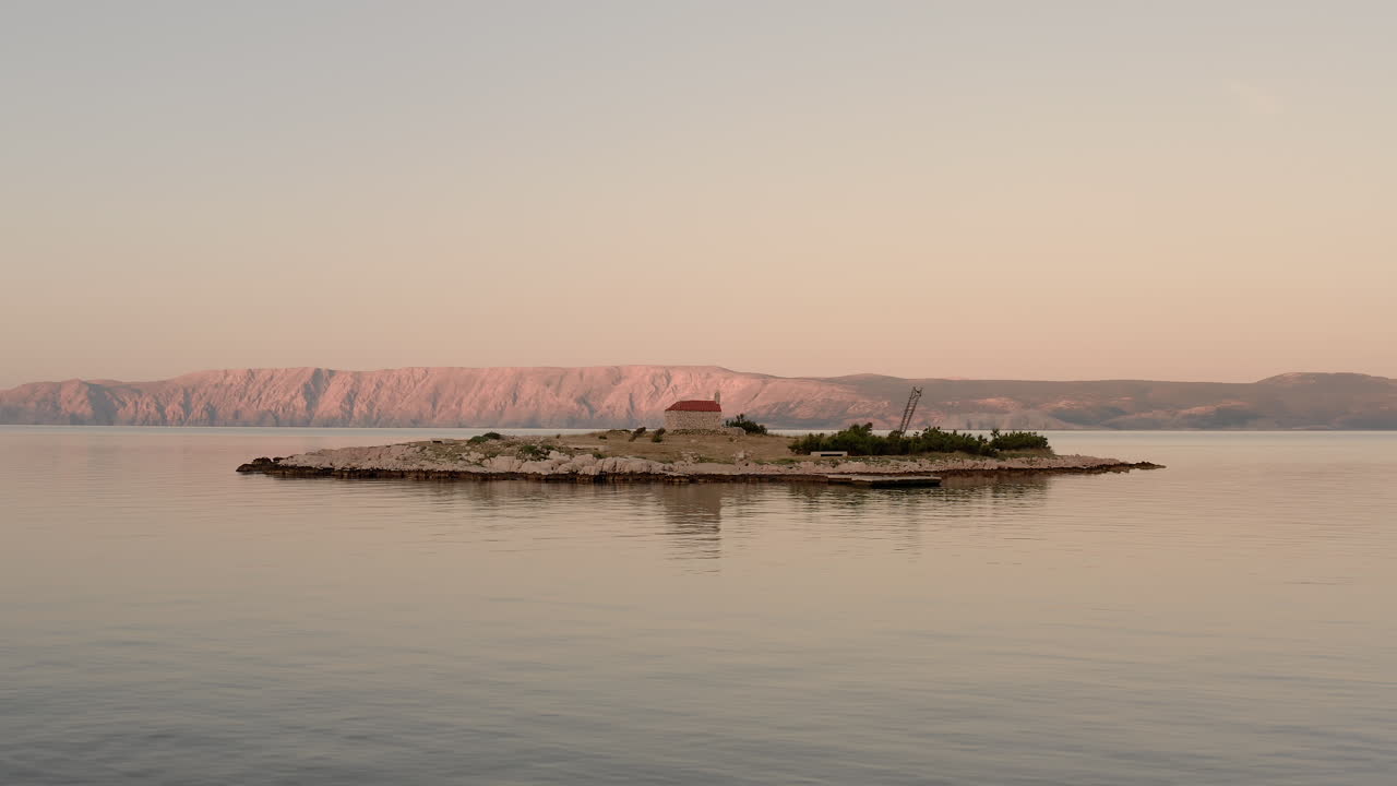 fotografía aérea de una pequeña isla en croacia en medio del mar durante el amanecer, vista clara del mar adriático durante la hora azul, capilla de sveti marin, novi vinodolski, hermoso destino de viaje
