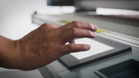 factory worker operating a machine with a touch screen panel