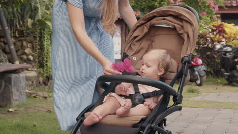 unrecognizable mother giving flower to baby