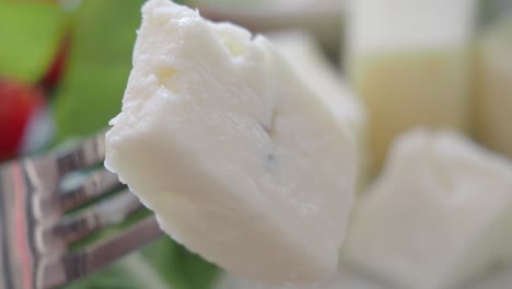 close-up of a fork holding a piece of feta cheese