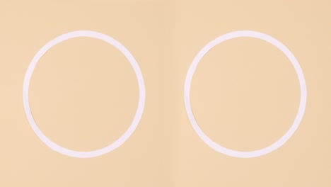 two copy space circles with nail polish bottles on beige background. stop motion