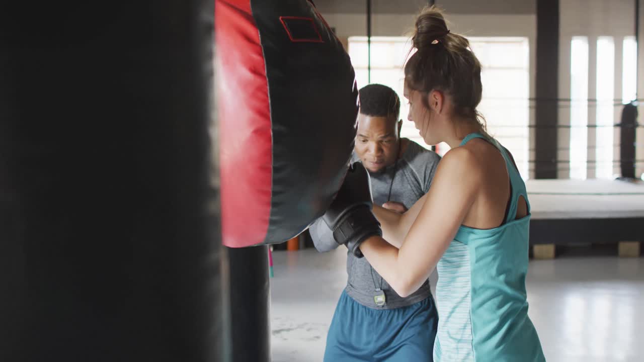 video de una mujer y un hombre en forma de boxeo en el gimnasio