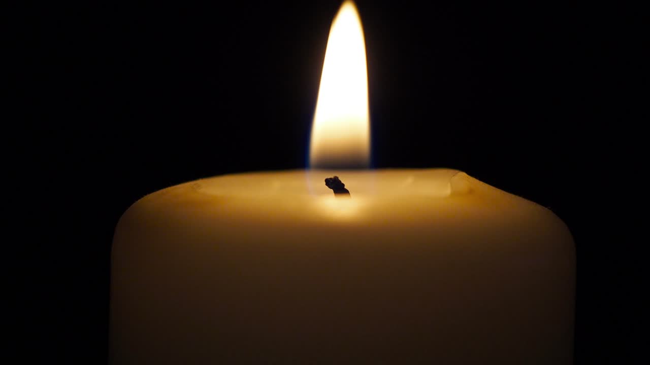 Jediná svíčka ve tmě, detailní záběr.