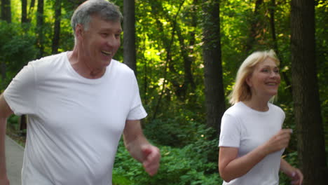 happy senior couple enjoying a run in the park