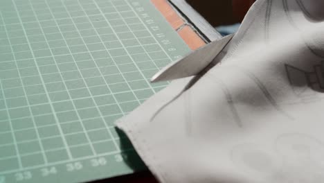 cutting along a sewn edge on a cutting board with scissors