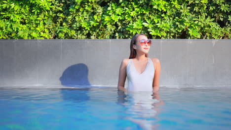 a young attractive woman stands in a swimming pool