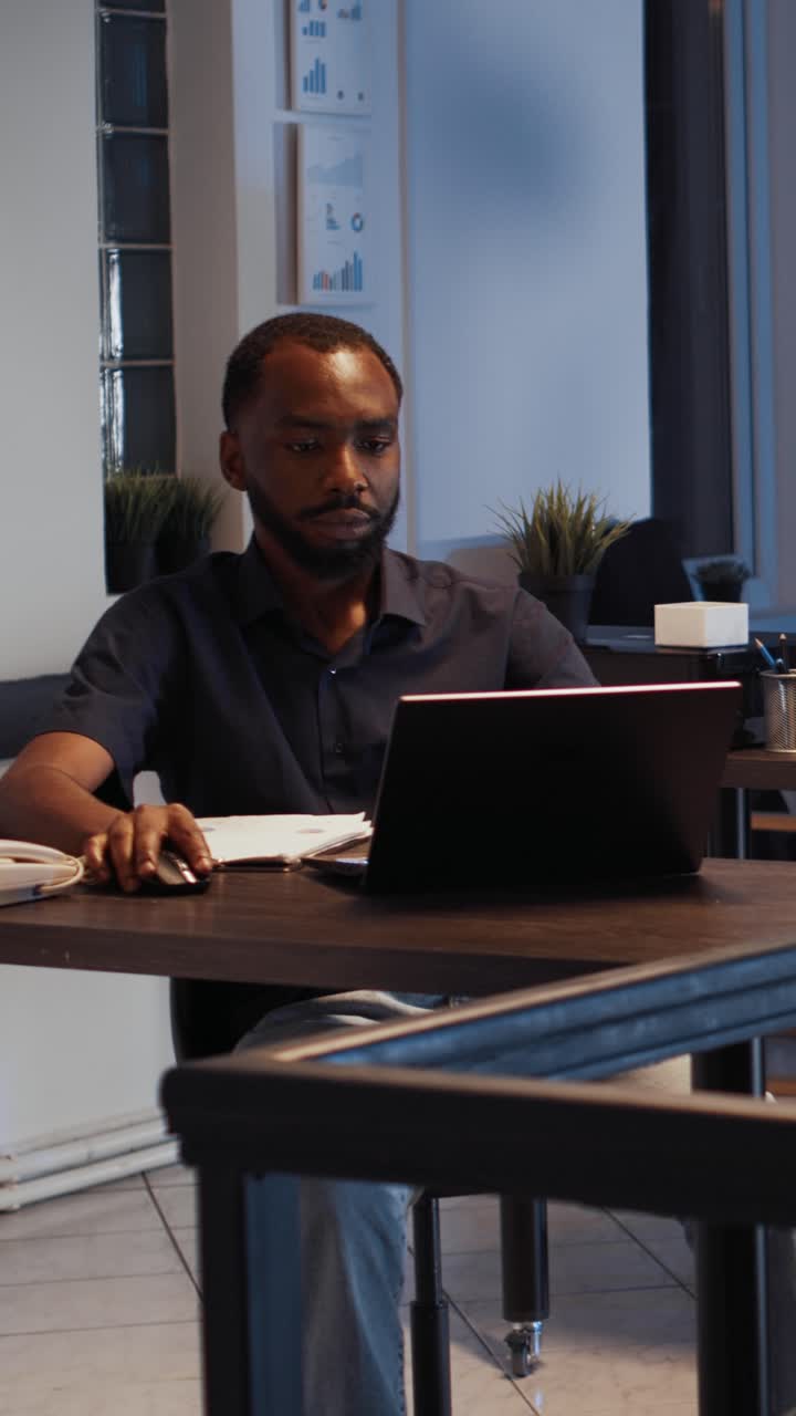 Vertical video: Corporate employee sending email on laptop at night
