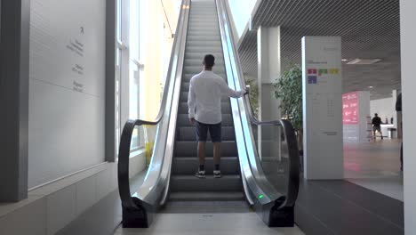 person using an escalator in a modern building