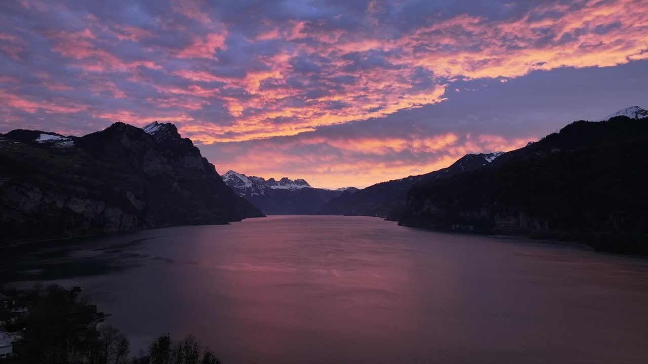 Aerial sunset sky reflecting on Walensee in Switzerland, with mountain silhouettes