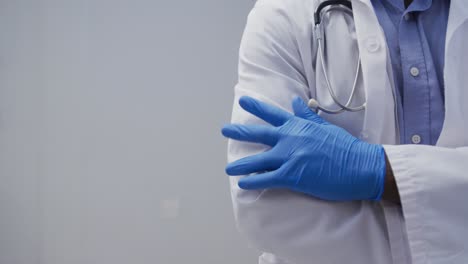 midsection of male doctor wearing surgical gloves