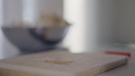 woman tosses mushrooms on chopping board