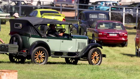 vintage car driving through a car show