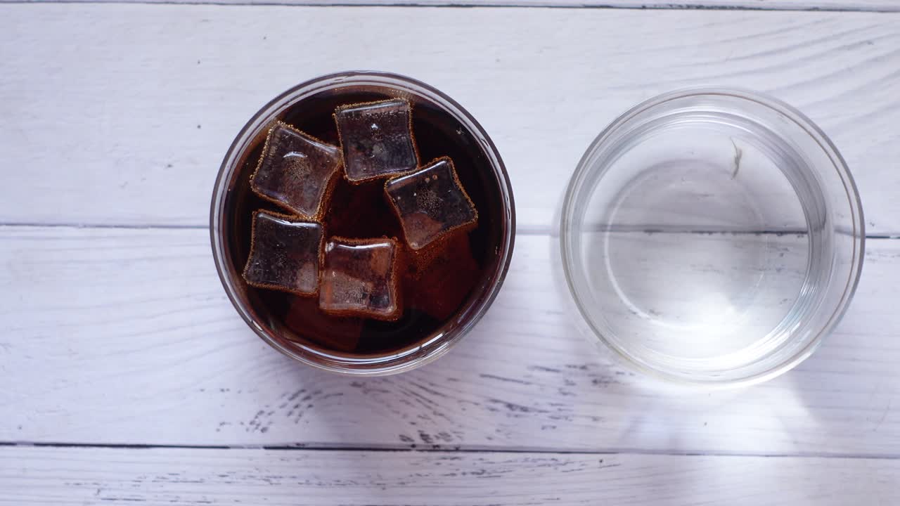 Bicchiere di cola con ghiaccio e bicchiere d'acqua
