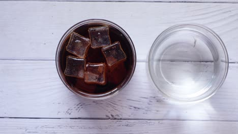 glass of cola with ice and glass of water