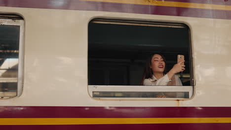 woman taking selfie on train window