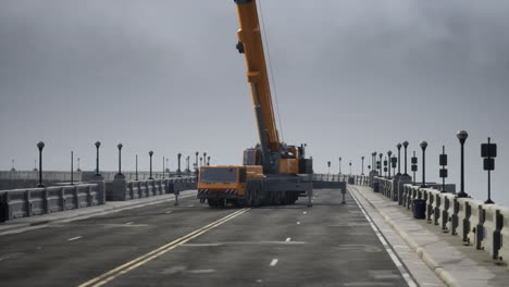 a crane truck driving on a bridge