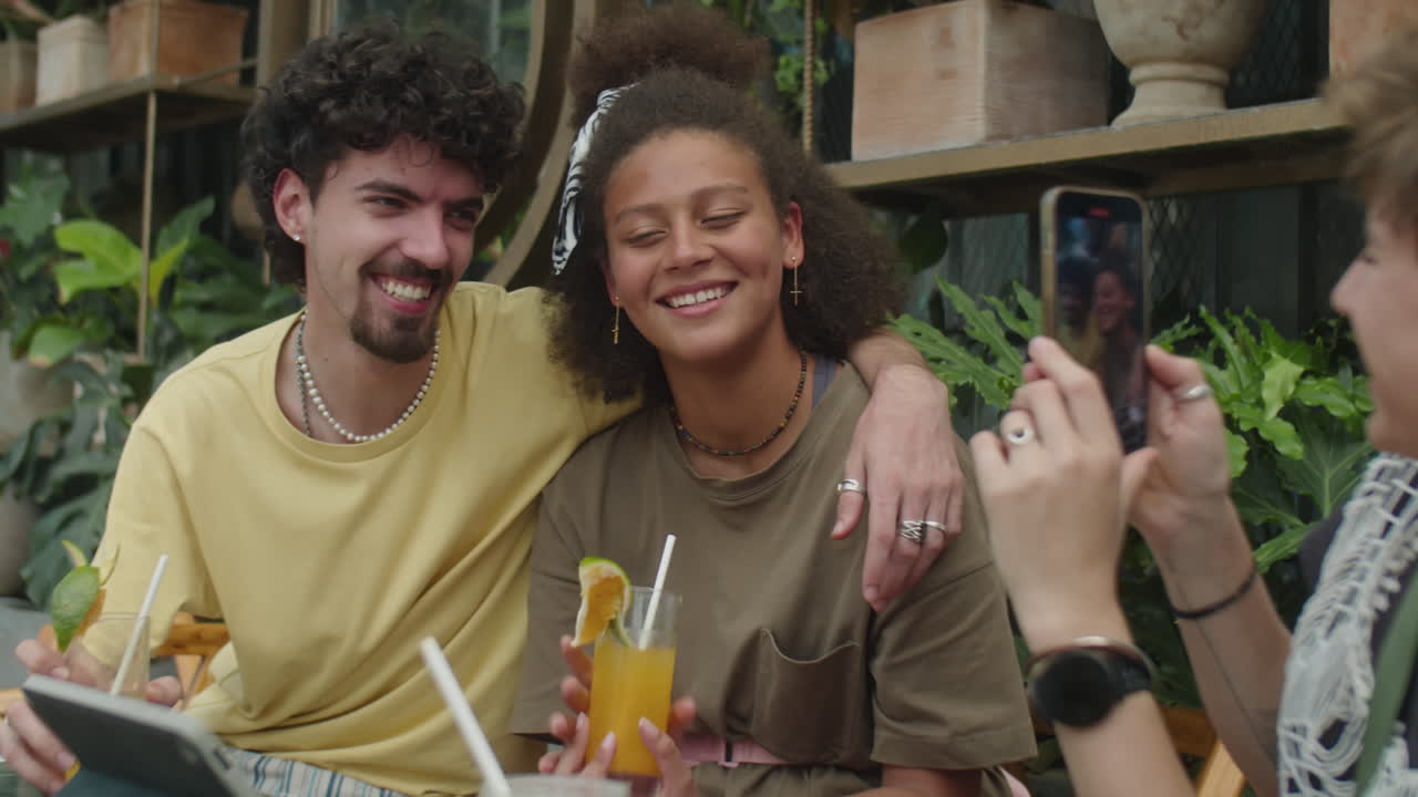 Girl Taking Photo of Friends in Outdoor Cafe