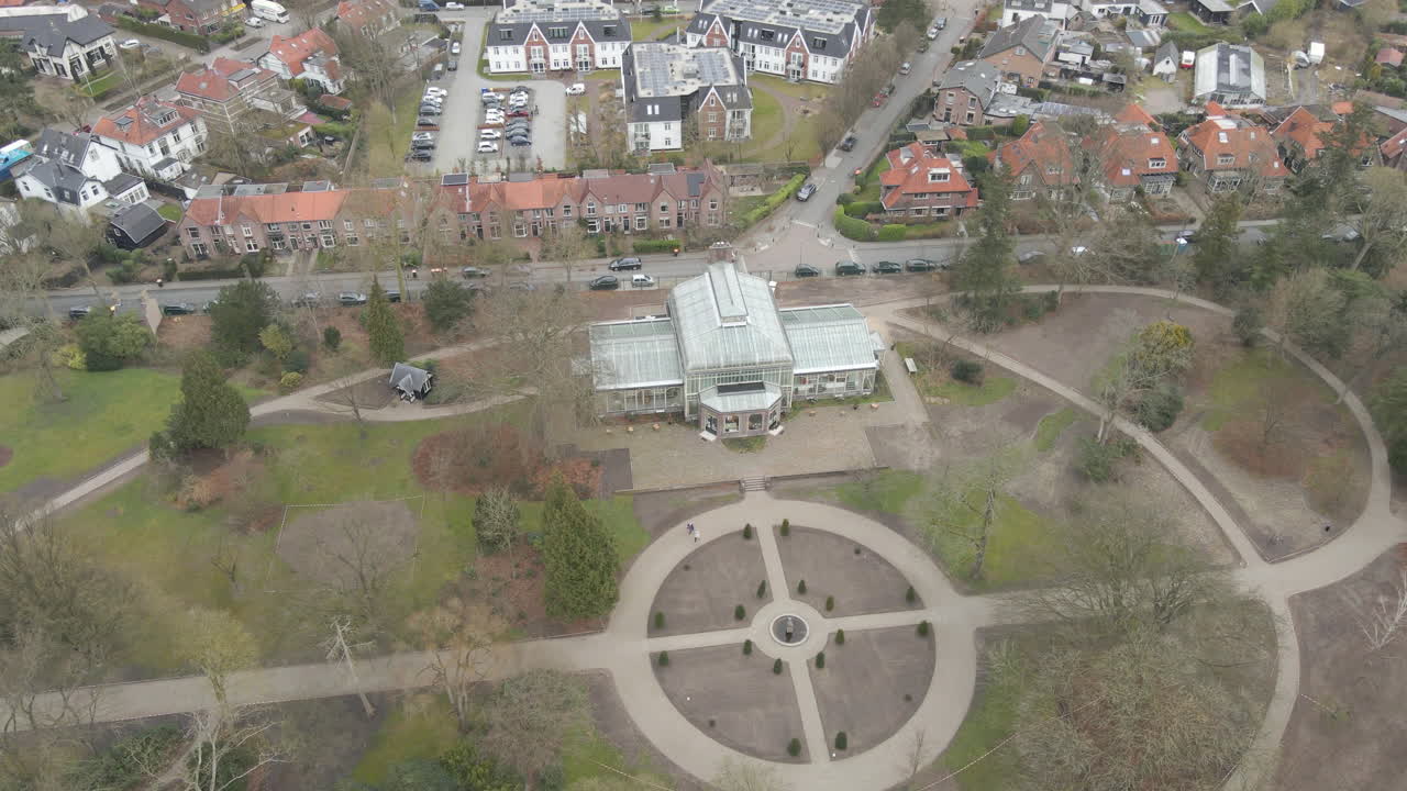 작은 녹색 공원에 있는 오래된 실내 식물원의 높은 공중