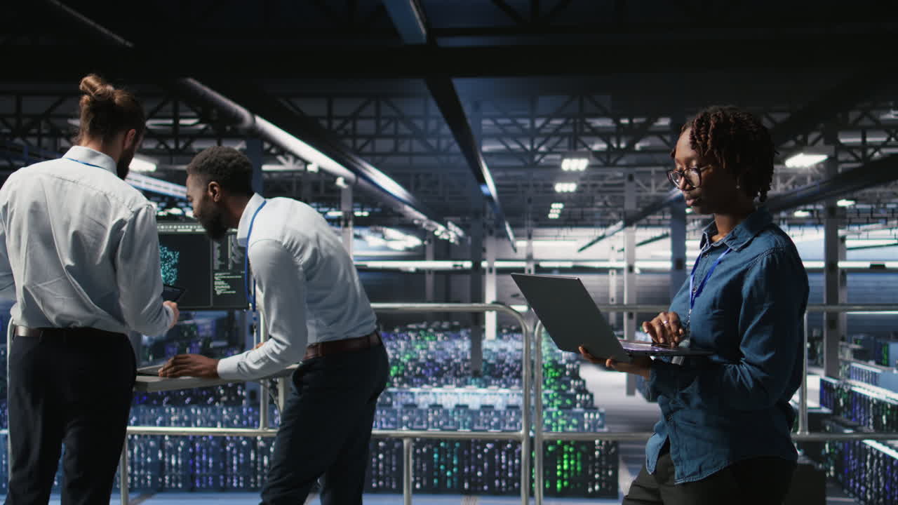 Happy woman in data center doing maintenance tasks on laptop