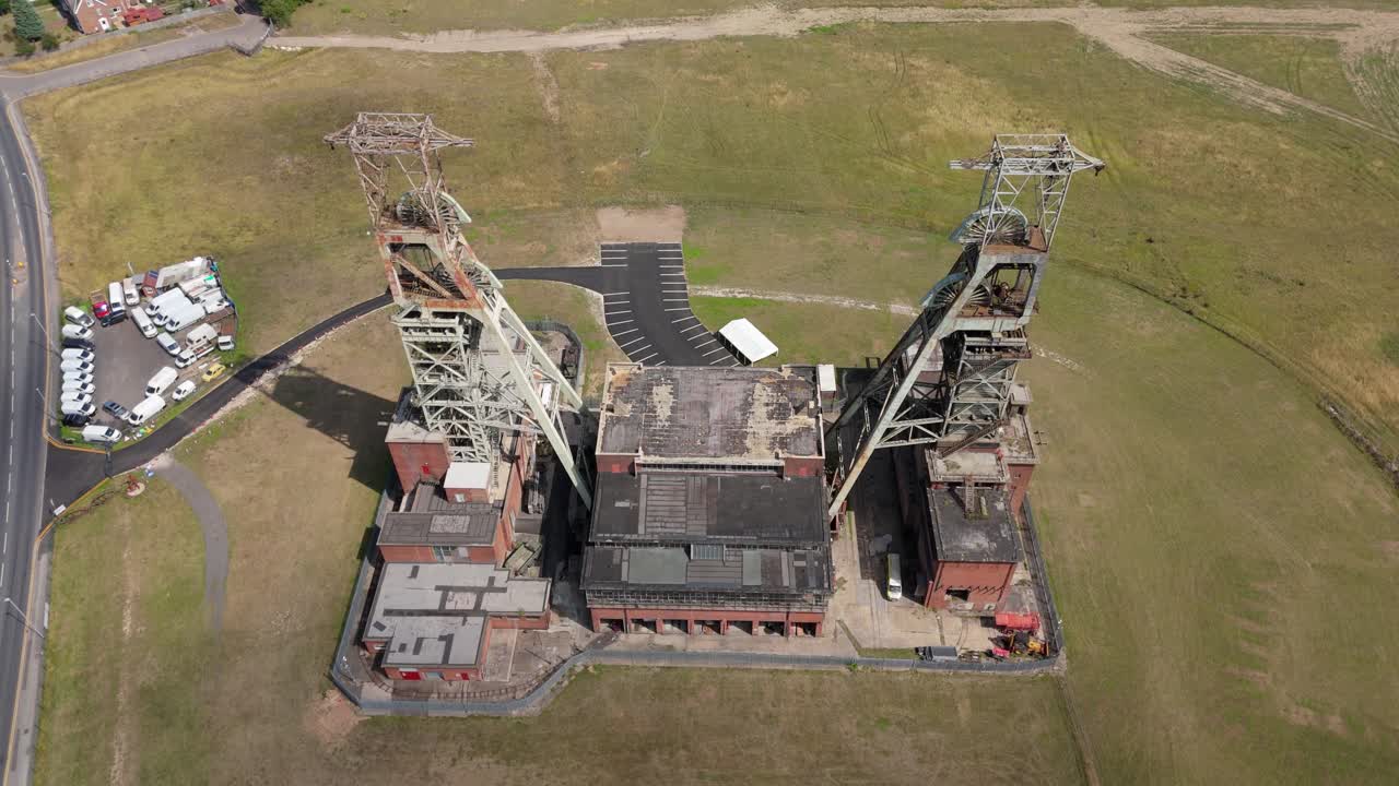 Aerial drone shot of coal mine headstocks surrounded by green fields Clipstone Nottinghamshire England UK