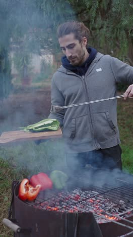 man grilling bell peppers outdoors
