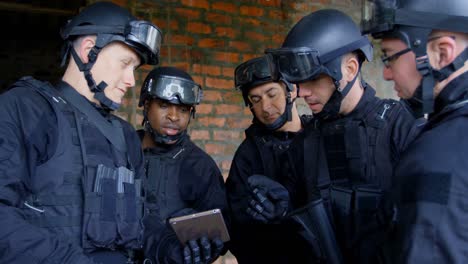 side view of mixed-race military soldiers with rifles planing and discussing their plan at base 4k