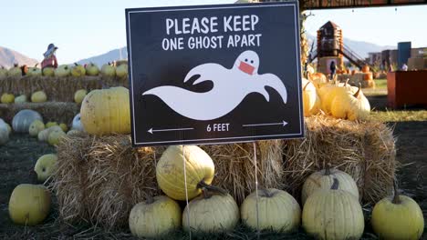 Por-Favor,-Mantenga-Una-Pantalla-Fantasma-Aparte-En-La-Entrada-De-Un-Huerto-De-Calabazas-Durante-La-Pandemia-De-Coronavirus-En-Utah,-Ee.uu.