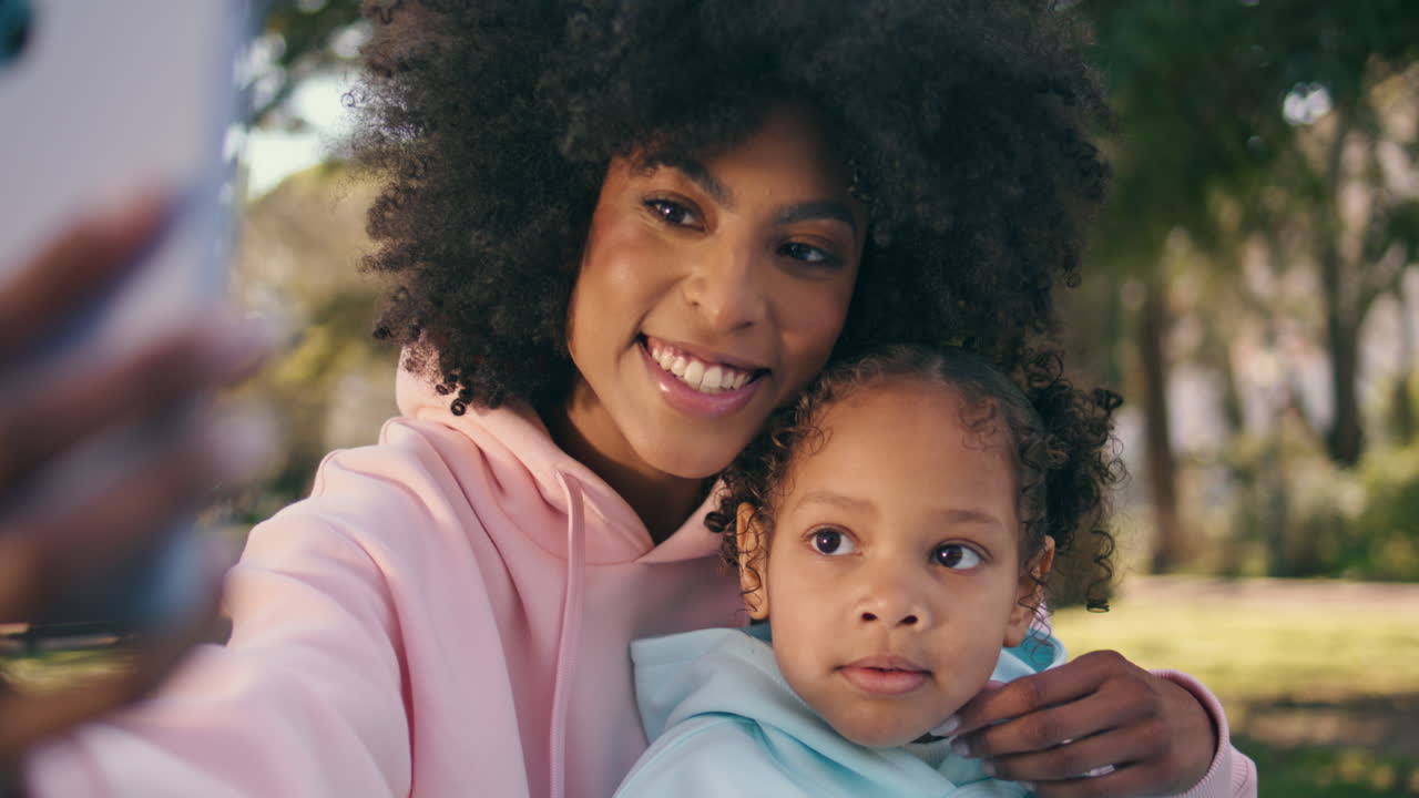 madre-hijo tomando fotos juntos en el teléfono en el hermoso prado verde de cerca.