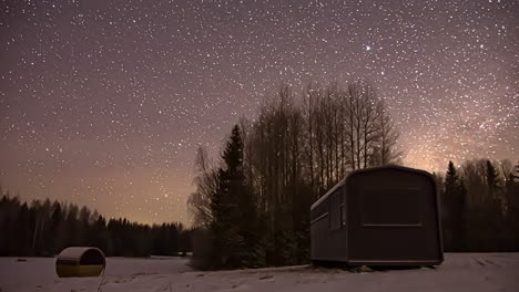 beautiful star trail over a snow covered meadow with a cabin in winter