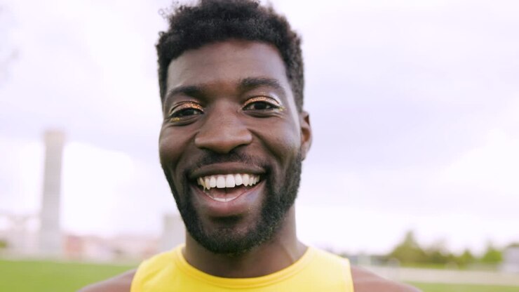Africain gay fluide de genre maquillé souriant en extérieur - Concept de la communauté queer et LGBT
