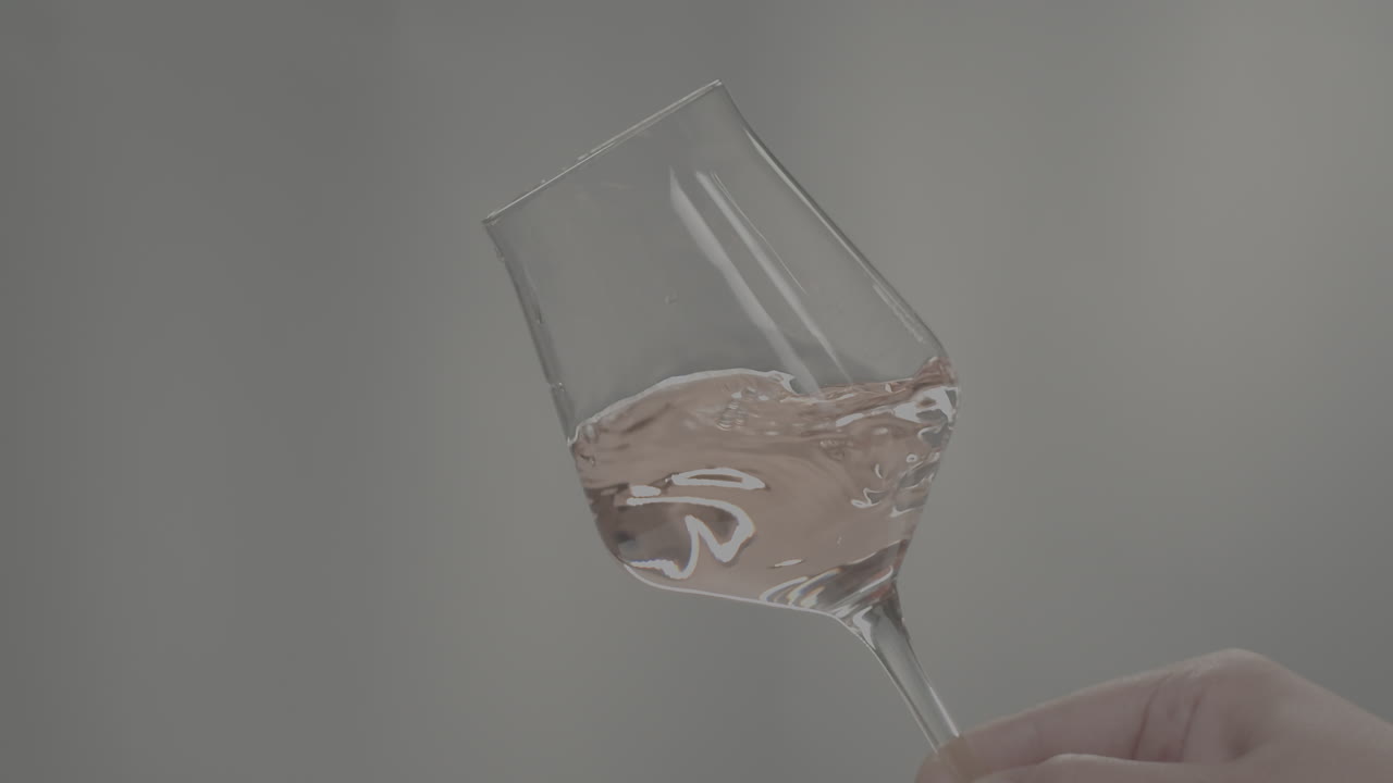 Rose Orange or white wine bottle and glass against a sunset in a peaceful vineyard, pouring of ecological natural wine. Cheers, hands with wine glasses, drinking alcohol.