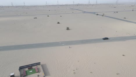 Aerial-tracking-of-black-Lamborghini-Urus-accelerating-on-desert-road-in-Dubai