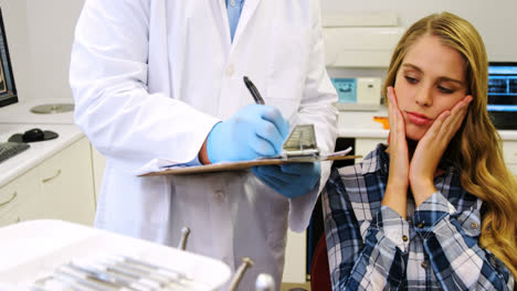 dentist preparing dental report of female patient