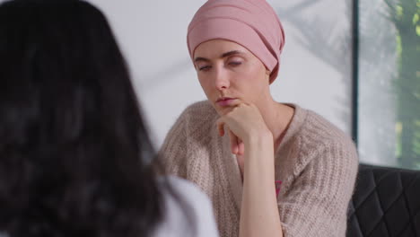 close up of serious young woman patient wearing headscarf undergoing chemotherapy treatment for breast cancer meeting with oncologist or doctor in hospital 1