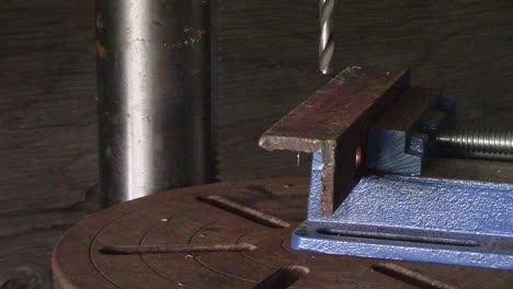 Slow-Motion---Drill-press-starting-and-beginning-to-cut-into-a-piece-of-steel-angle-iron