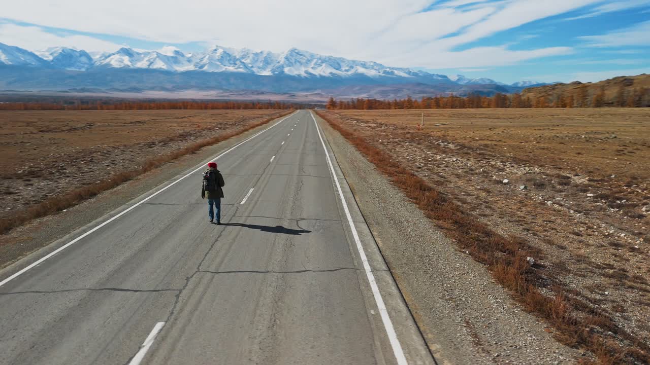 Person Hiking on Mountain Road