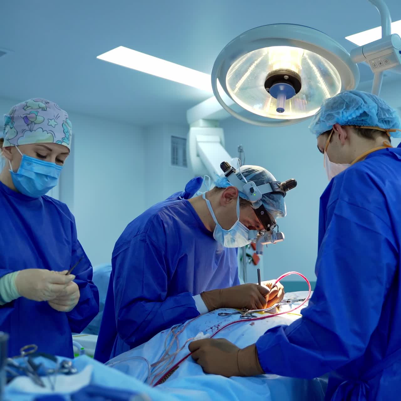 Process of trauma surgery operation. Group of surgeons wearing protective masks operating with surgery equipment